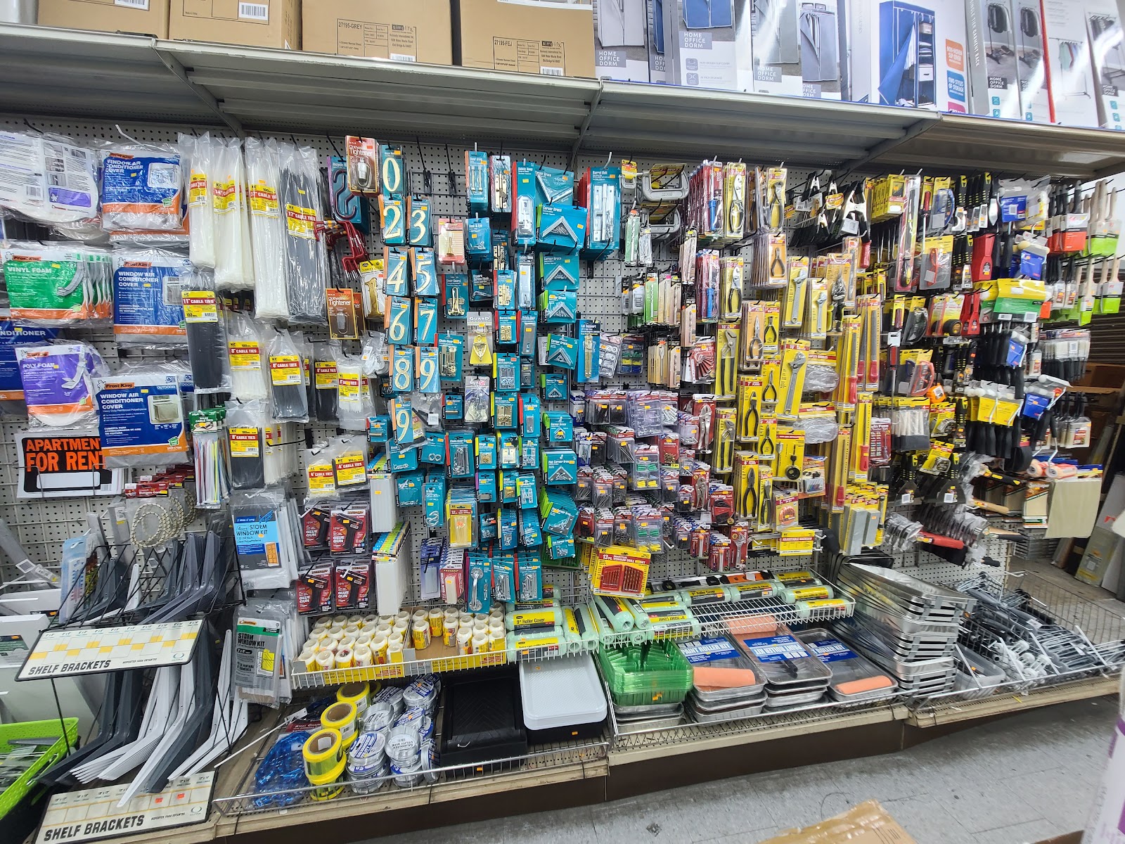 Kitchen supplies and housewares wall with baking trays and utensils at Peoples Department Store