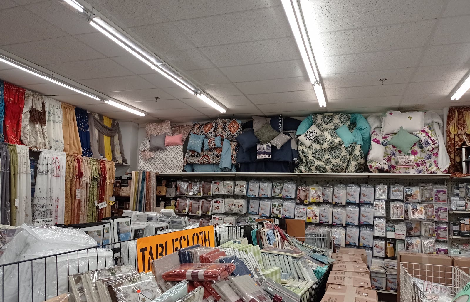 Comforter sets and bedding on display in the bedding aisle at Peoples Department Store